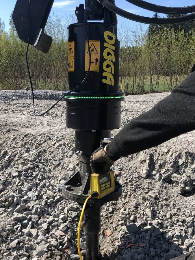 Głowica napędowa Digga z bliska podczas montażu pali śrubowych pod fundament szklarni w Cassandras Trädgård w Porvoo